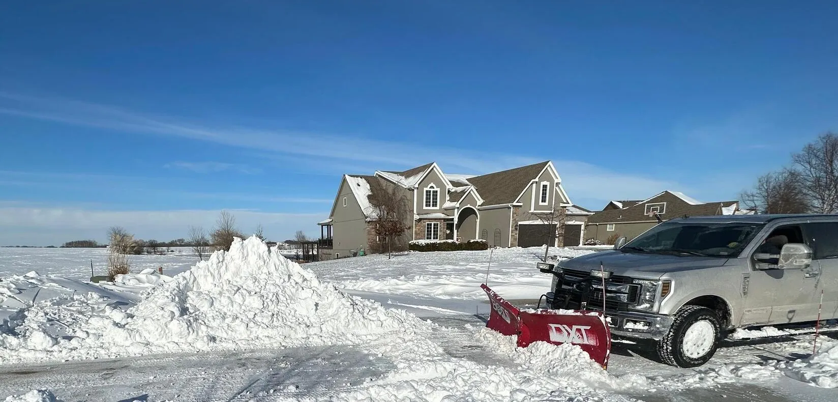 Commercial snow plow clearing a parking lot