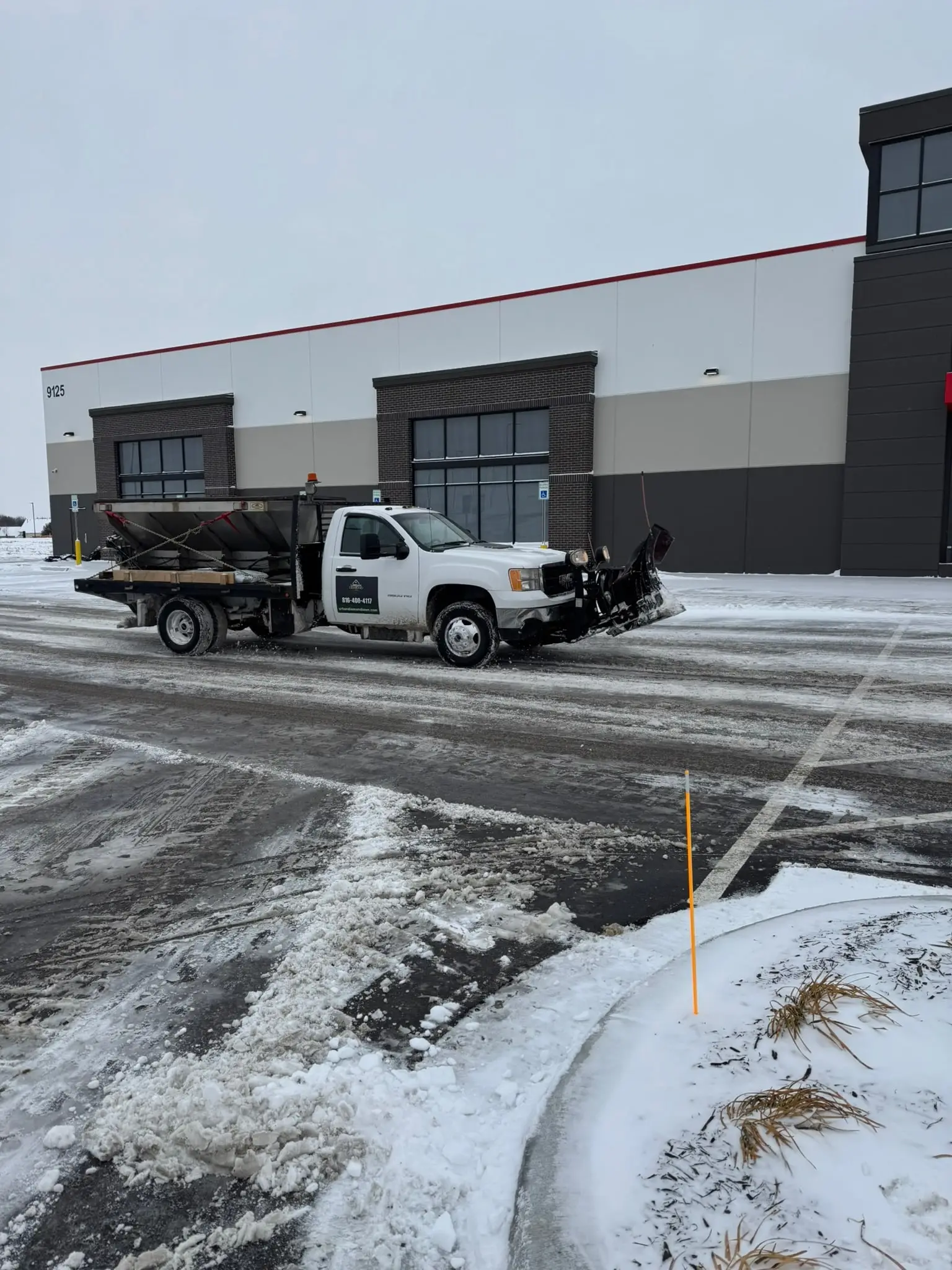 Urban Diamond plow truck clearing a commercial parking lot