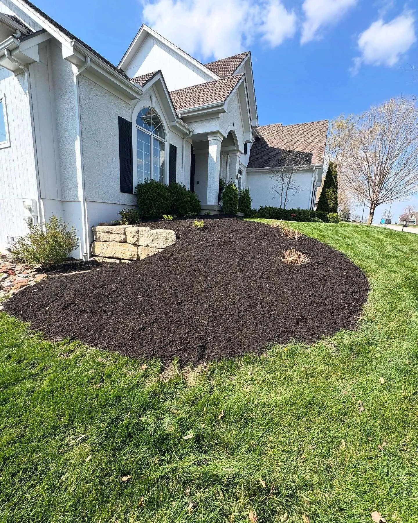 Flowerbed mulching service with fresh dark mulch