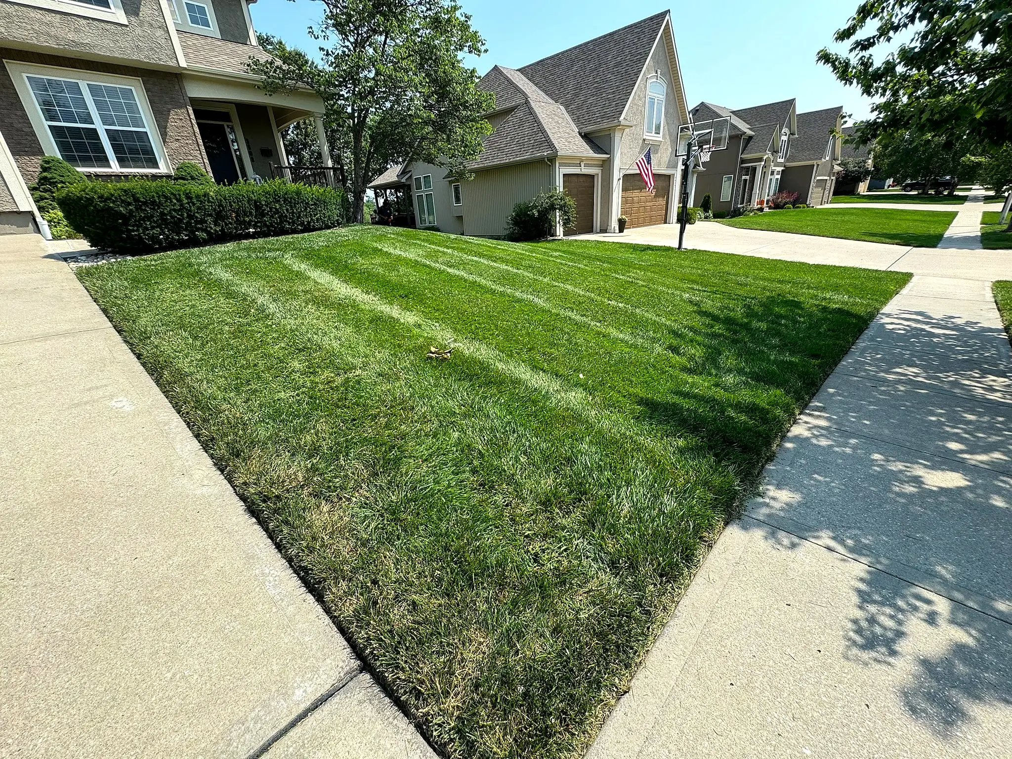 Crisp lawn stripes and a clean walkway edge on a Kansas City Northland front yard